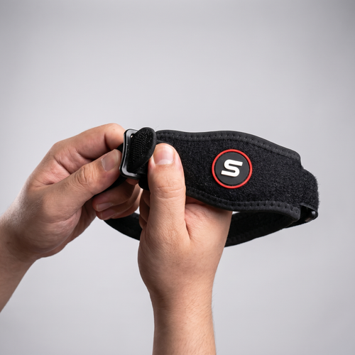 Hand threading the strap through the elbow brace buckle