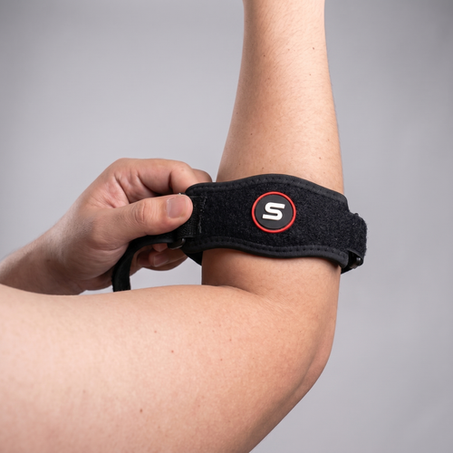 Person placing the elbow brace on their forearm